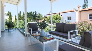 Un espace extérieur aménagé, abrité et doté d’un canapé, de chaises et d’une table basse.