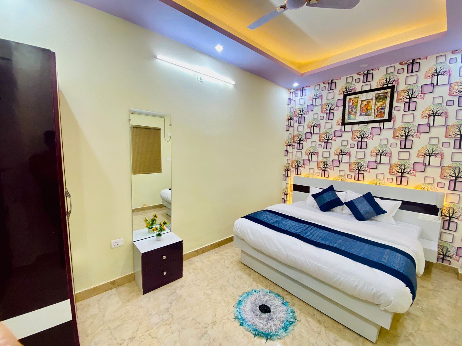A bedroom with a bed, bedside table, and a mirror.