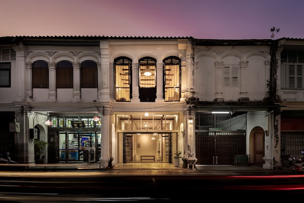 Classic two-story building with arched windows and decorative moldings, featuring a welcoming entrance and courtyard access.