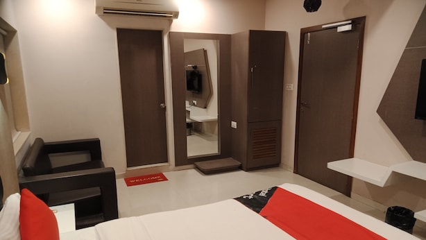 Une chambre d’hôtel comprenant un lit, un bureau, un miroir, une armoire et une salle de bain.