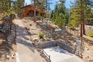 A wooden cabin with a stone staircase leading to a wooden deck.