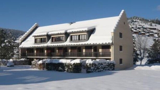 A chalet-style building with a steeply pitched roof, wooden balconies, and a snow-covered landscape. - Studio in Corrençon-en-Vercors, 4 pers, pets allowed (Corrençon-en-Vercors)