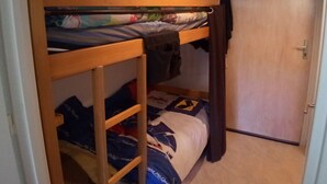 A bunk bed with a wooden frame, a lower shelf, and a door to the right. - Studio in Corrençon-en-Vercors, 4 pers, pets allowed (Corrençon-en-Vercors)