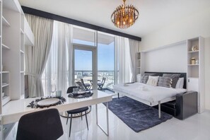 A modern bedroom with a large bed, a dining table, and a view of the city. - Danube Miraclz 2903 · Breathtaking view compact & modern spacious studio (Arjan)