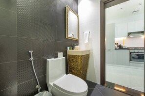 A modern bathroom with a shower, toilet, and sink.