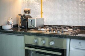 A kitchen with a gas stove, a toaster, and a coffee maker on the countertop. - Danube Miraclz 2903 · Breathtaking view compact & modern spacious studio (Arjan)