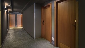 Un pasillo con puertas de madera, suelo alfombrado e iluminación empotrada.