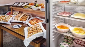 Un bufé con distintos alimentos y un refrigerador lleno de productos lácteos.