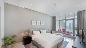 A modern hotel bedroom with a large bed, a desk, a chair, and a city view. - BUSINESS BAY - Damac Maison prive, 2907 · Spectacular Burj Khalifa view service apartment (Dubai)