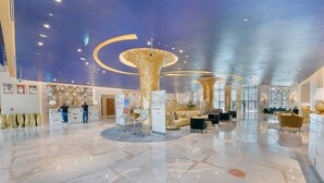 A spacious lobby with a marble floor, a reception desk, and a seating area with sofas and armchairs. - BUSINESS BAY - Damac Maison prive, 2907 · Spectacular Burj Khalifa view service apartment (Dubai)