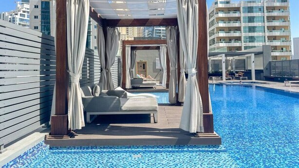 A rooftop pool area with a canopy, a bed, and a view of the cityscape. - Studio One 913 Dubai Marina · Funky STUDIO Dubai Marina outstanding facilities (Dubai Marina)