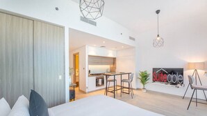 A modern hotel room with a large bed, a kitchenette, and a dining area. - Studio One 913 Dubai Marina · Funky STUDIO Dubai Marina outstanding facilities (Dubai Marina)