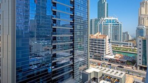 A high-rise building with a glass facade reflecting the surrounding cityscape. - Studio One 913 Dubai Marina · Funky STUDIO Dubai Marina outstanding facilities (Dubai Marina)