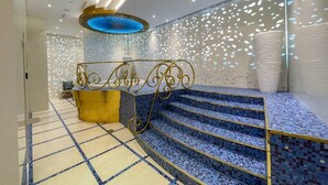 Un interior moderno con una escalera, un mostrador de recepción y paredes con diseños.