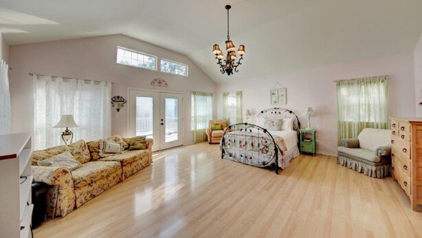 A spacious bedroom with a large bed, a sofa, and a dresser. - Large home, perfect for family reunions (Ingram)