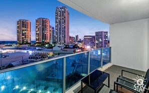 Enjoy breathtaking city and ocean views from the spacious balcony with comfortable seating.