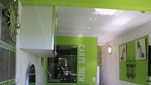 A room with a bed, a mirror, and a green wall with the text "CARPE DIEM". - Cozy Air-Conditioned Studio for 2 with Terrace & Parking in Agde (Cap d'Agde naturisme)