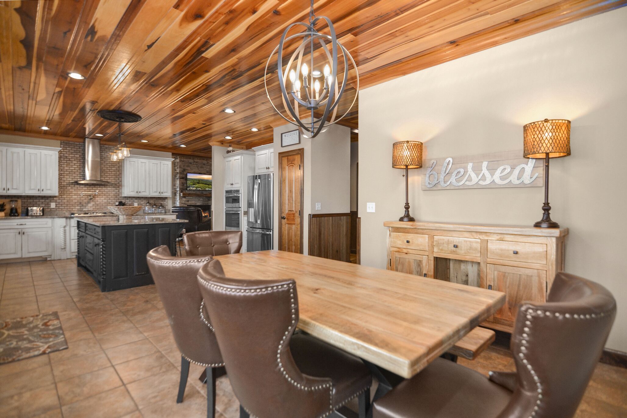 A spacious kitchen with a wooden ceiling, a central island, and modern appliances.