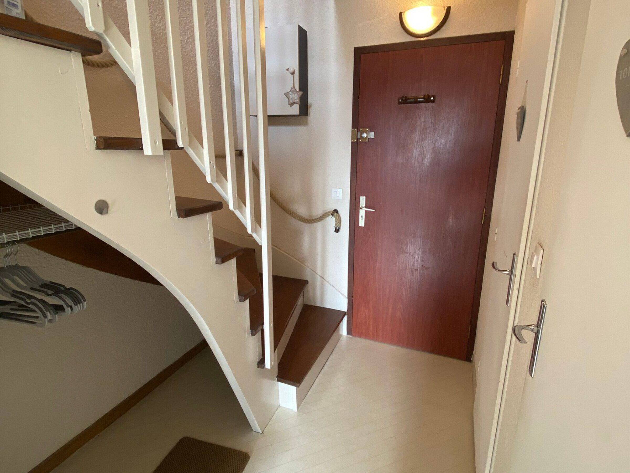 A staircase leading to a wooden door with a light fixture above it.