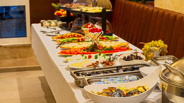 Buffet com diversos tipos de comida e uma área de estar.