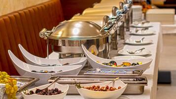 Una mesa de buffet con diversos alimentos y utensilios.