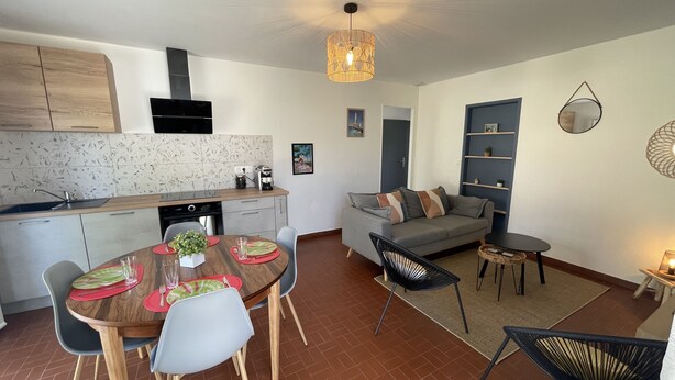 A modern kitchen with a built-in oven and a dining area with a round table and chairs. - 600m Plage (Saint-Palais-sur-Mer)