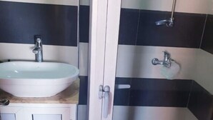 A bathroom with a white sink, a mirror, and a shower area with black and white tiles. - luxury apartment in the center of gueliz, near carre eden mall (Marrakesh)