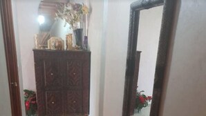 A hallway with a red patterned rug, a wooden cabinet with decorative items, and a mirror on the wall. - luxury apartment in the center of gueliz, near carre eden mall (Marrakesh)
