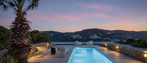 Una piscina al aire libre de temporada, sombrillas, tumbonas