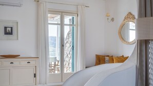 A bedroom with a bed, a dresser, a mirror, and a window with curtains. - Villa Hola Mykonos (Mykonos)