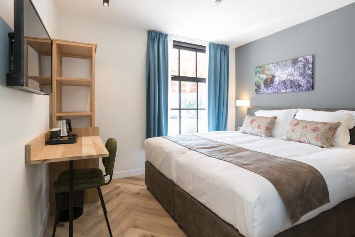 A bedroom with a bed, a desk, and a chair.