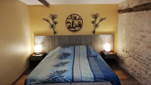 Ein Schlafzimmer mit einem Bett, zwei Nachttischen, einer Wanduhr und einem Wanddekor.