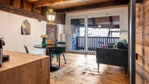 Interior de madera con comedor, sofá y vista al exterior.