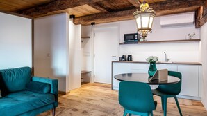 Una cocina moderna con microondas, lavamanos y una zona de comedor con sillas color turquesa y una mesa.