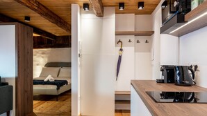 Una cocina compacta con estufa integrada, cafetera y encimera de madera.