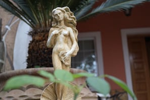 A statue of a woman in a garden setting.