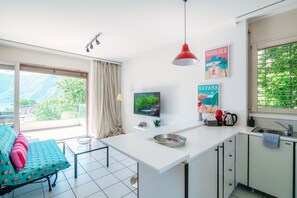 Una cocina moderna con una isla grande, un área de comedor con un sofá y vistas a las montañas.