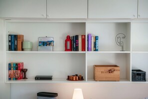 A bookshelf with books, a lamp, and a wooden crate labeled "BERTANI".