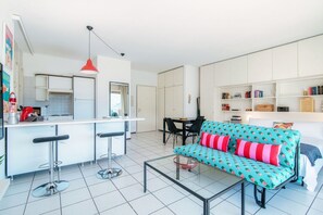 A modern apartment with a kitchen, dining area, and living room. - Open-space apartment with lake view (PANORAMIC STUDIO) (Lugano)