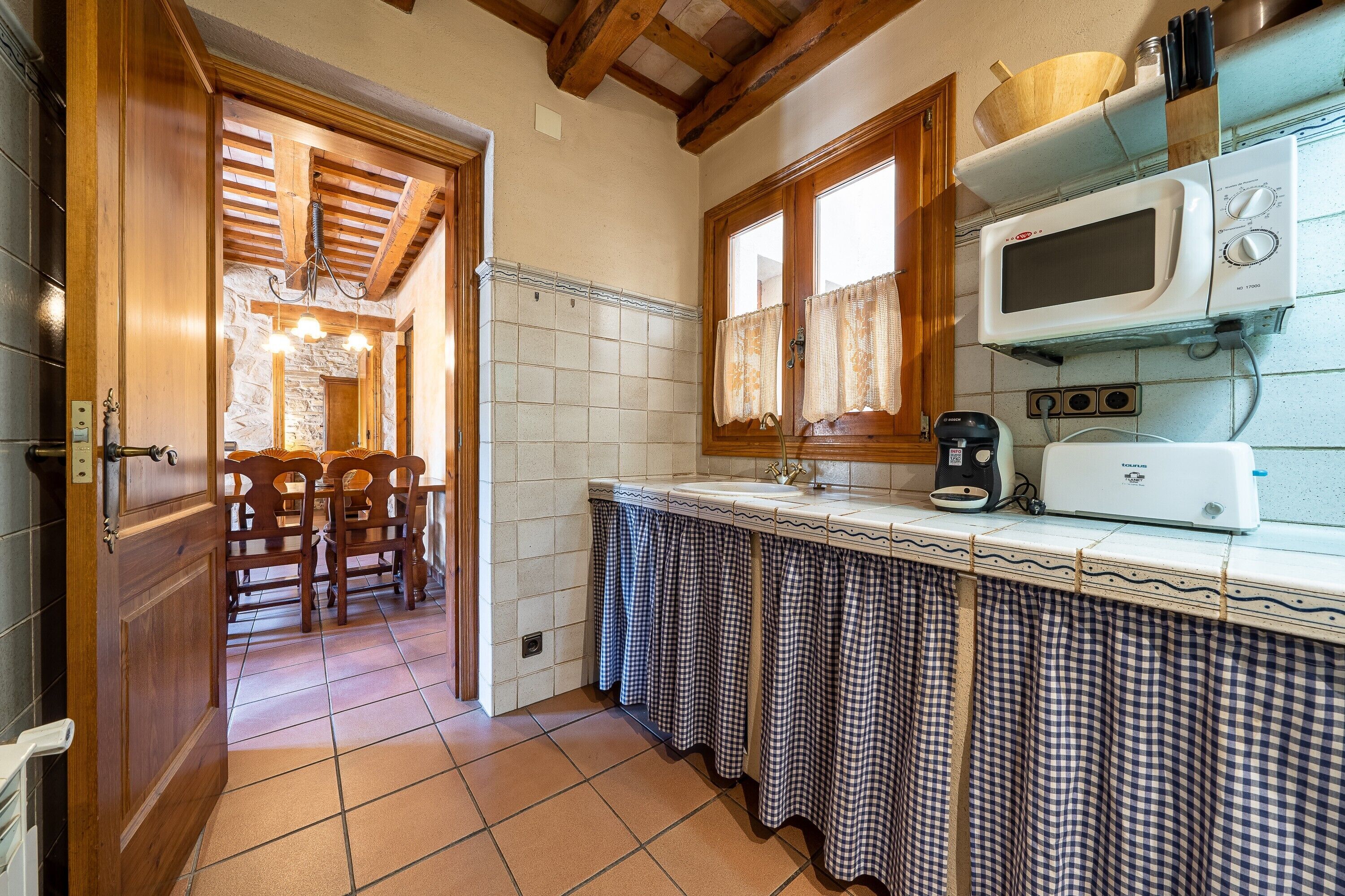 Una cocina con microondas, tostadora y armarios de madera.
