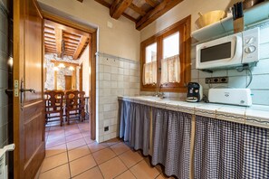 Une cuisine équipée d’un four à micro-ondes, d’un grille-pain et de meubles de rangement en bois.
