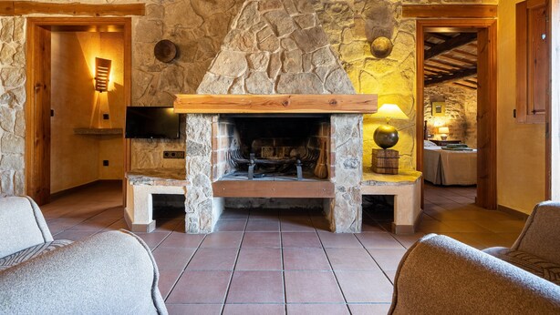 A stone fireplace with a wooden mantel, a television above it, and a lamp on a side table. - Apartment 'El Clos 3' with Mountain Views, Private Terrace and Wi-Fi (CONESA)