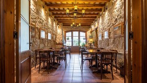A restaurant with stone walls, wooden beams, and a tiled floor. Tables and chairs are arranged for dining. - Apartment 'El Clos 3' with Mountain Views, Private Terrace and Wi-Fi (CONESA)