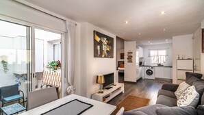 En moderne stue med sofa, fjernsyn og spiseplads.