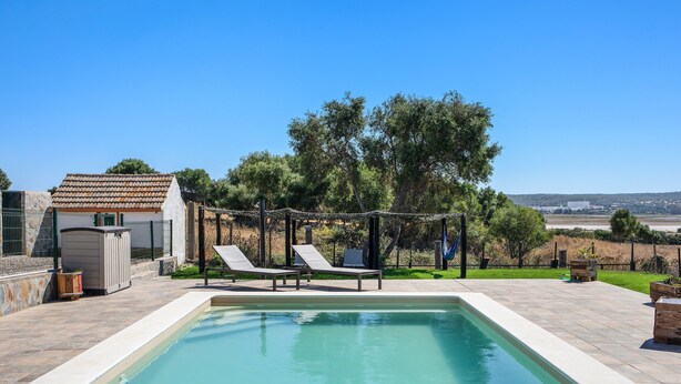 A swimming pool with lounge chairs, a small shed, and a view of the countryside. - Holiday Home 'Casa Andrea' with Mountain Views, Shared Pool & Wi-Fi (Barbate)