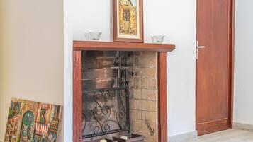 Una chimenea con repisa, una puerta y un cuadro enmarcado encima.