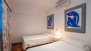 A room with two beds, a bedside table with a lamp, and two abstract paintings on the wall. - Vacation Home 'Tanamar' near Beach with Balcony & Wi-Fi (Puerto Pollensa)