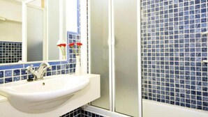 A bathroom with a white sink, a mirror, and blue-tiled walls. - Vacation Home 'Tanamar' near Beach with Balcony & Wi-Fi (Puerto Pollensa)