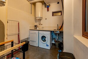 A laundry area with a washing machine, dryer, and a water heater. - 'Apartment Rafael' with Sea View, Terrace & Wi-Fi (Port de Pollença)