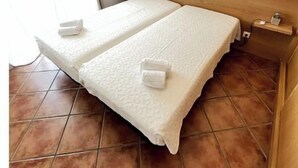Ein Doppelbett mit Holz-Kopfteil, zwei Nachttische und eine Wandleuchte.